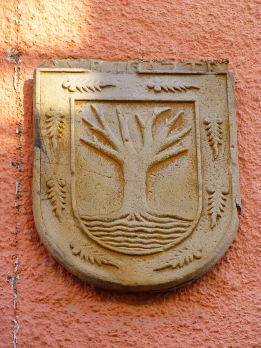 Escudo con un árbol sobre ondas de agua en Segura.