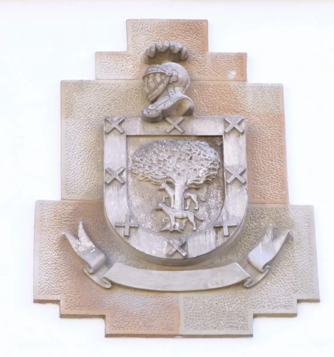Escudo con roble y lobo rodeado de una bordura con aspas, bajo un yelmo, en la iglesia de San Miguel Arcángel de Mimetiz.