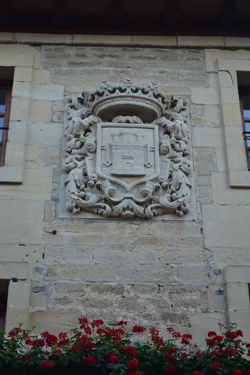 Escudo de Laguardia con corona y castillo en la fachada del ayuntamiento.