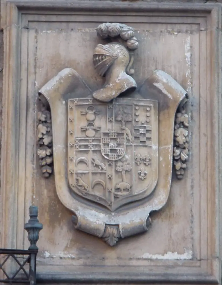 Escudo con numerosos cuarteles bajo un yelmo con penacho en la casa-palacio de los Álava-Velasco, calle Zapatería, Vitoria-Gasteiz.