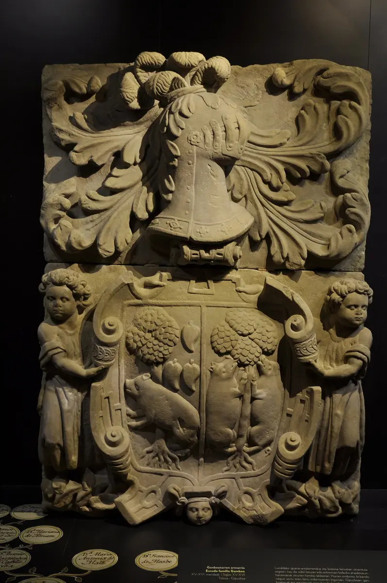 Armarria atribuida a la familia Gamboa, conservada en el museo San Telmo: escudo partido, con yelmo y dos niños que lo sujetan. A la izquierda de quien mira, un árbol con un jabalí y tres figuras en forma de hoja; a la derecha, un árbol con dos animales. No coincide con el blasón de Gamboa de las fichas (tres panelas azules sobre oro).