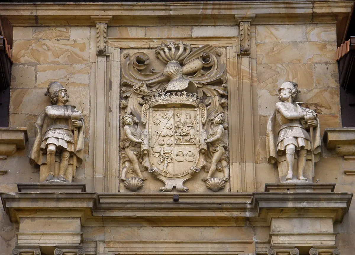 Escudo con corona, yelmo y dos niños como soportes, entre dos estatuas de soldados, en el palacio de los Duques de Lazcano, Lazkao.