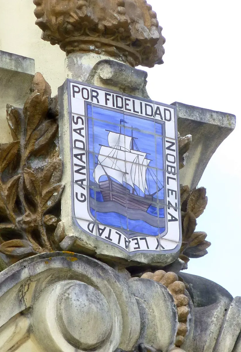 Escudo cerámico con un barco de velas y el lema «Por fidelidad, nobleza y lealtad» en el puente de María Cristina, Donostia.