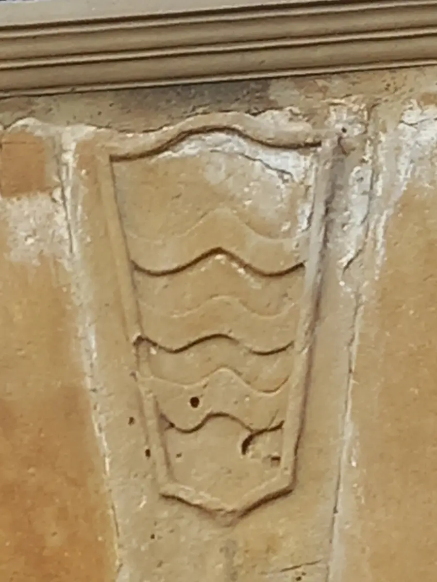 Escudo con bandas onduladas en el dintel de la puerta del palacio de cabo de armería de Eristáin.