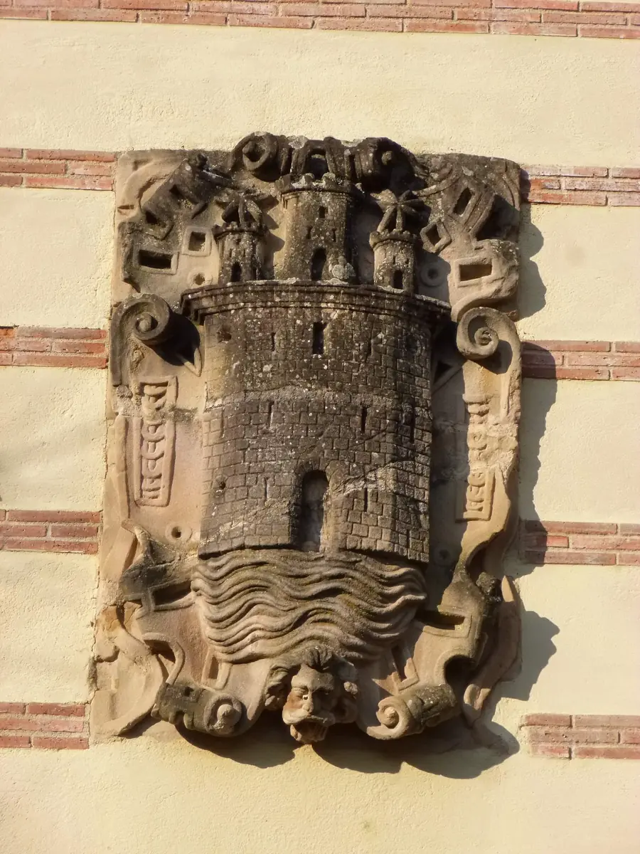 Escudo con una torre almenada sobre ondas de agua en Segura.