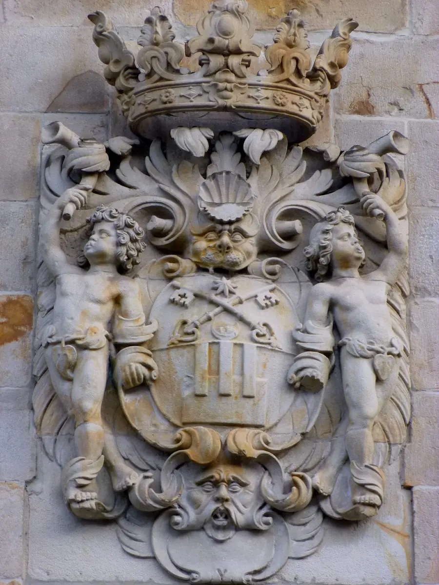 Escudo de la villa con corona, dos niños como soportes y mascarón en el ayuntamiento de Bergara.