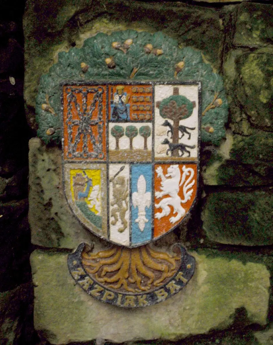 Escudo policromado de siete cuarteles con raíces y la leyenda «Zazpiak bat» en Pasaia Donibane.