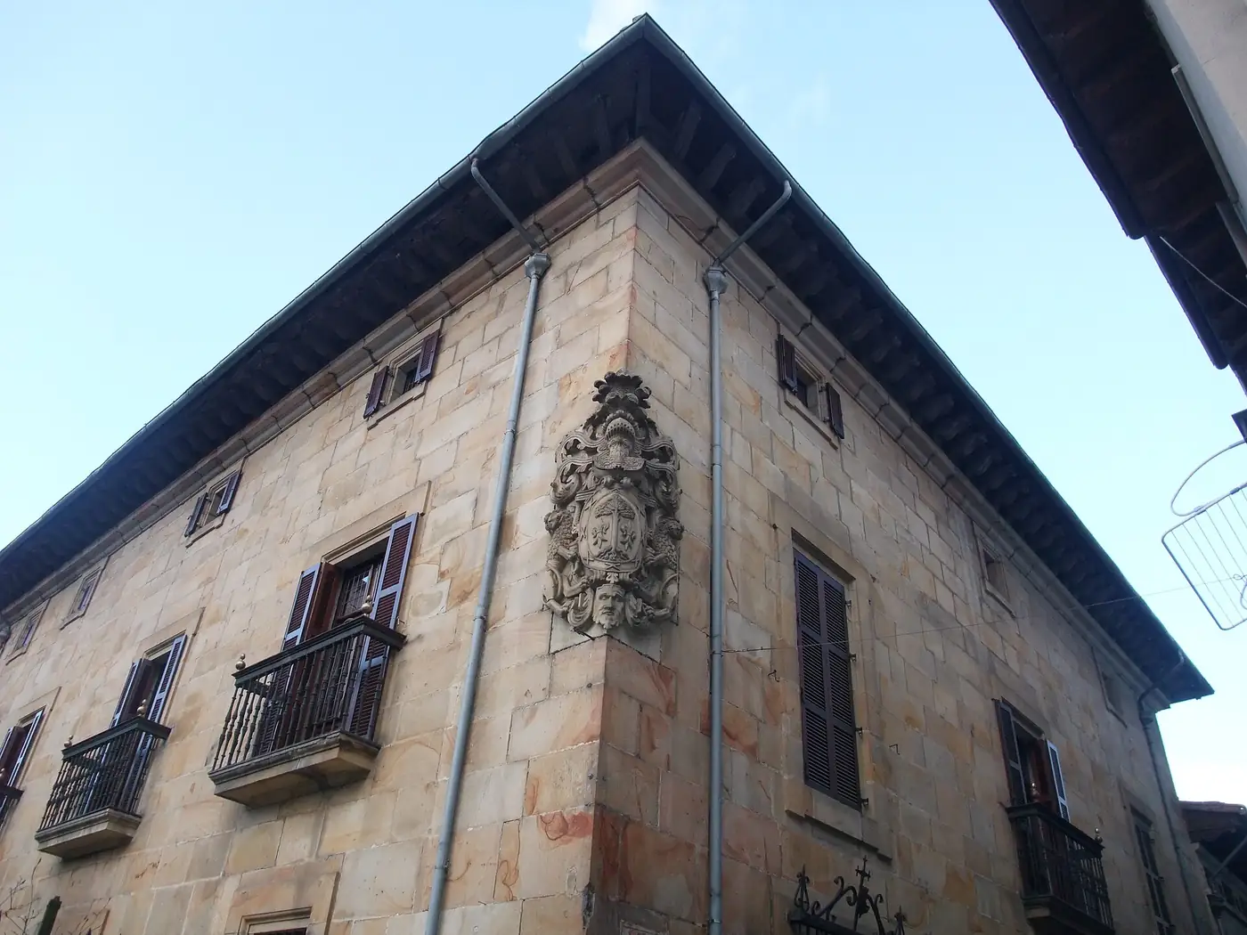Esquina del palacio de Arespakotxaga-Mendibil, con un escudo de armas en el piso alto y alero de madera.
