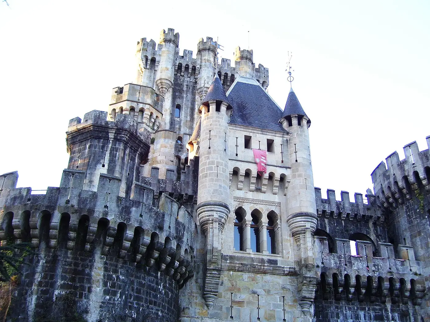 Detalle del cuerpo central del castillo de Butrón (obra de la reconstrucción del siglo XIX), con torrecillas y un adarve almenado volado sobre arquillos.