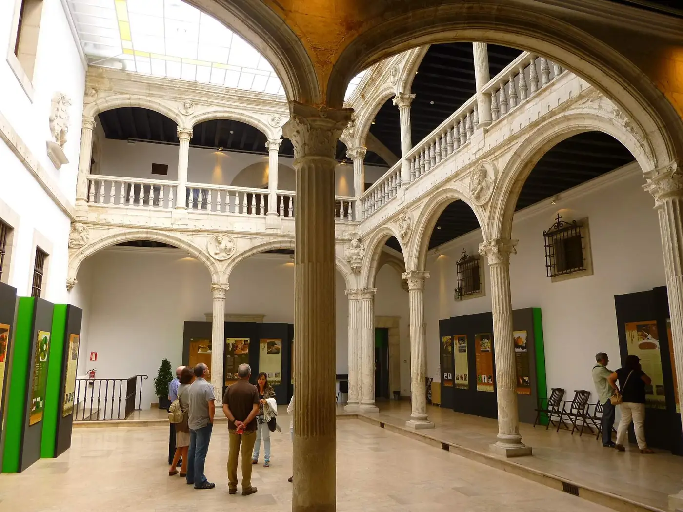 Galerías del patio del palacio de Escoriaza-Esquivel vistas desde la planta baja, con arcos sobre columnas y cubierta de cristal.