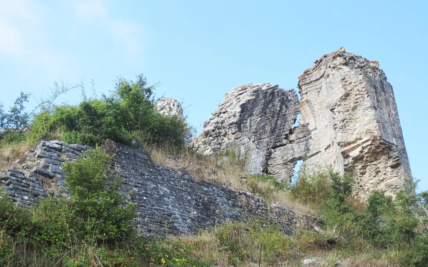 Restos del castillo de Guevara: dos grandes masas de muro en ruina sobre un talud de piedra.