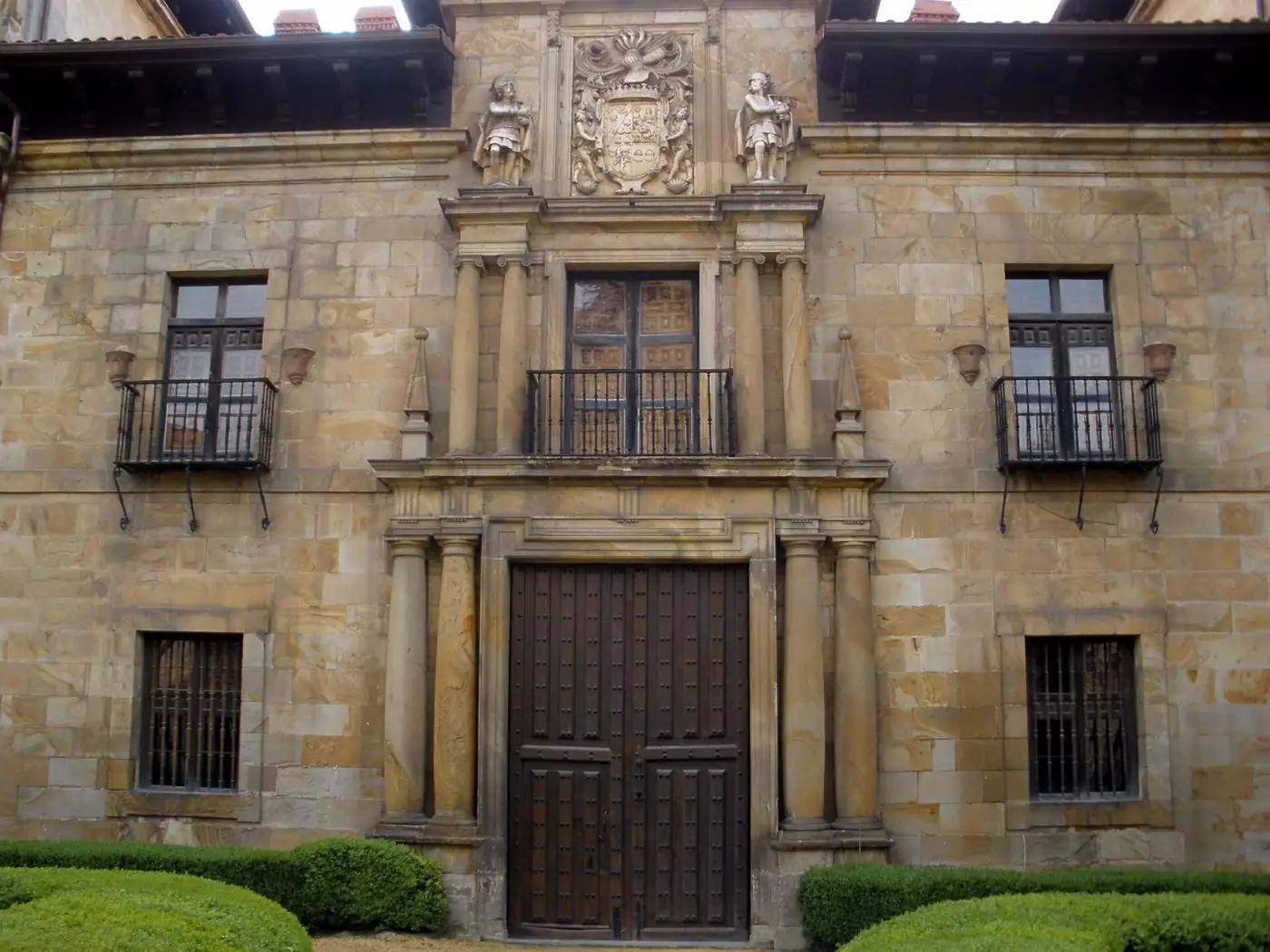 Portada del palacio de Lazkao con columnas pareadas, balcones de hierro y un escudo en lo alto.