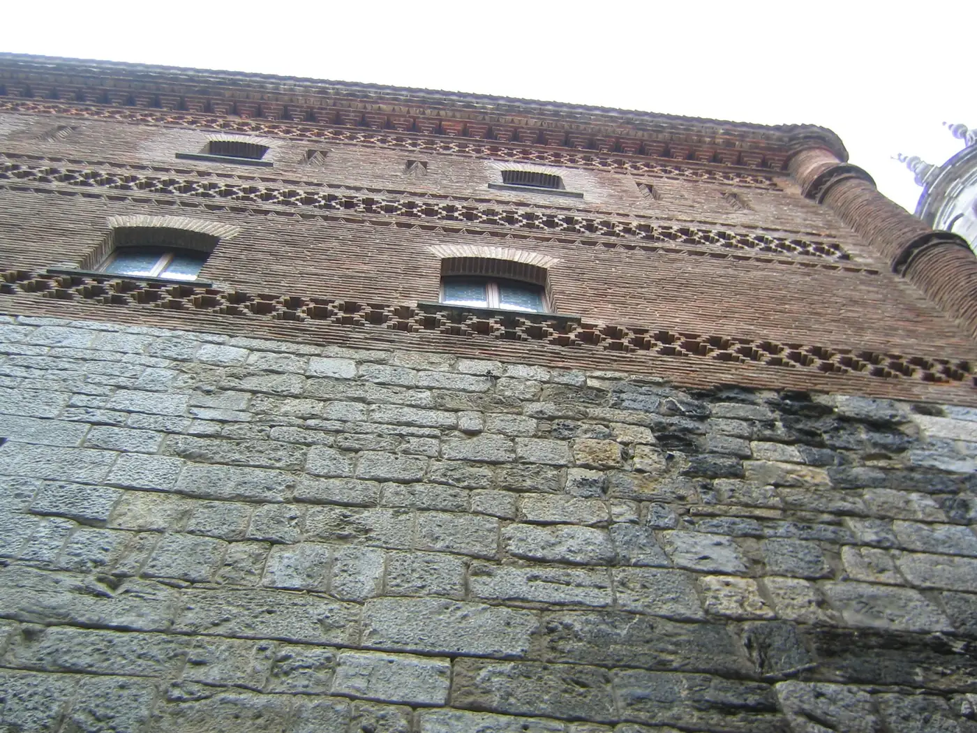 Fachada de la Santa Casa de Loiola: zócalo de sillería y pisos altos de ladrillo con frisos de dientes de sierra.
