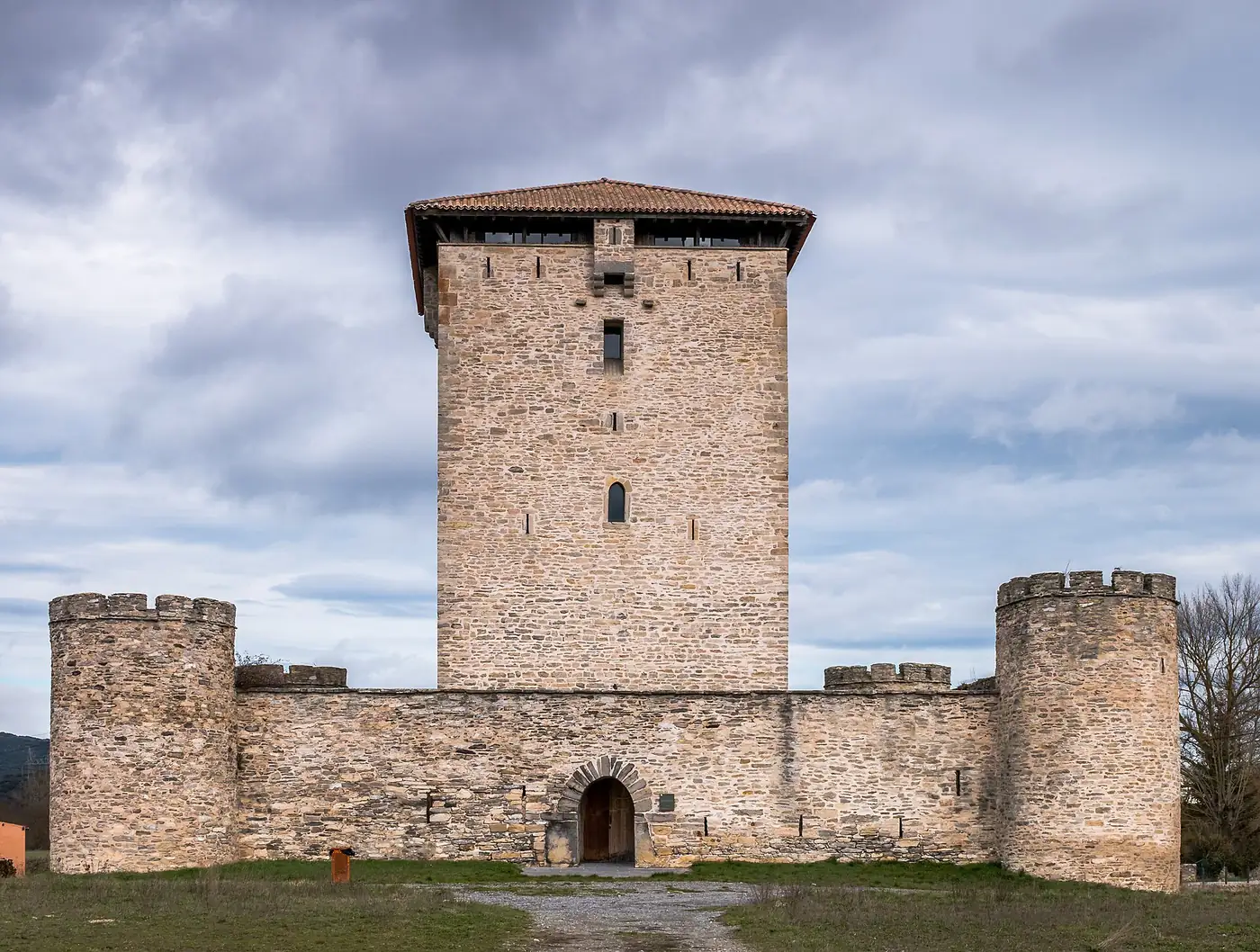La torre de Mendoza de frente, con su recinto de muro y cubos cilíndricos almenados.