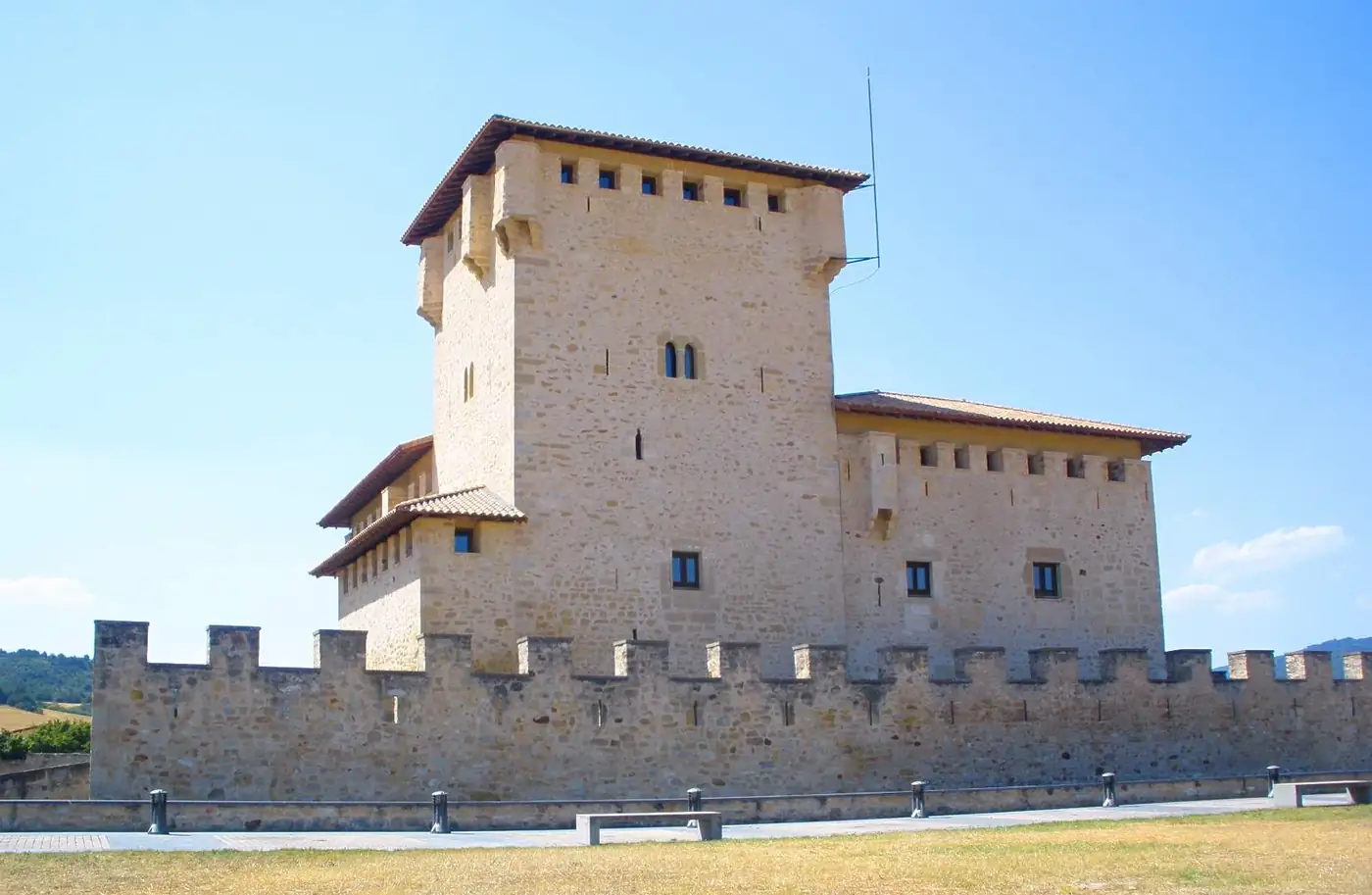 La torre-palacio de los Varona desde fuera del muro, con el remate de la torre y las almenas del recinto.