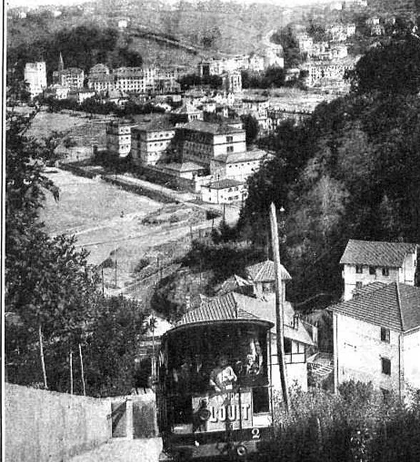 Un coche del funicular de Igueldo en su vía, con edificios de San Sebastián al fondo. La revista lo rotula «Vista de los nuevos jardines de Ondarreta y del Monte Igueldo. Funicular del Monte Igueldo».