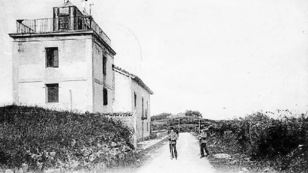 El edificio del observatorio meteorológico en el Monte Igueldo, con un camino de tierra a su lado.