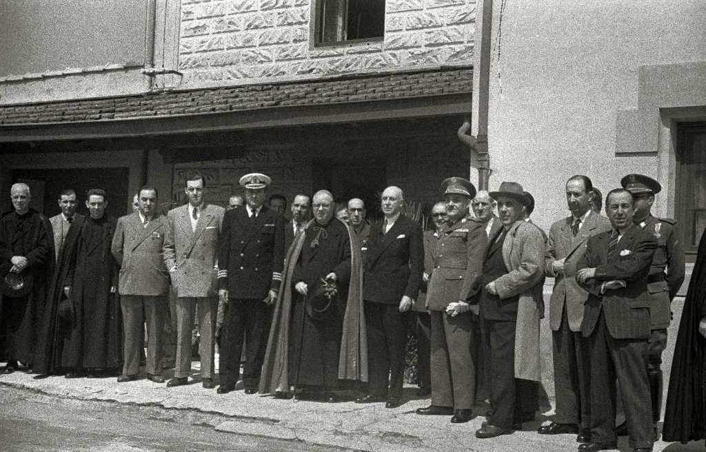Autoridades civiles, militares y religiosas ante un edificio del monte, en la inauguración de unos locales del observatorio.